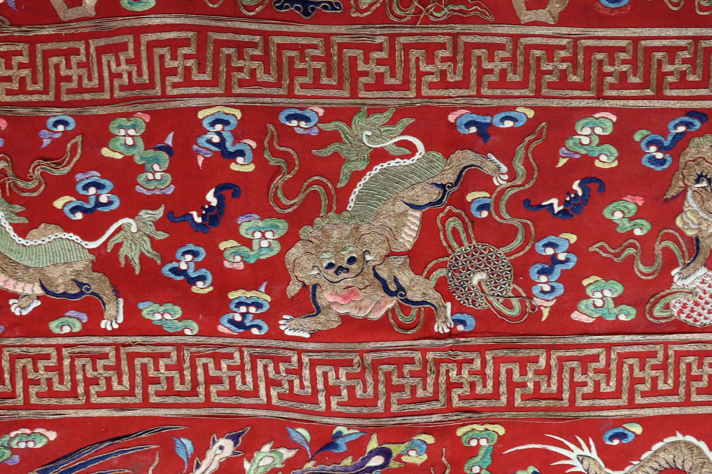 A Chinese embroidered silk ‘dragon, phoenix and lion’ panel or table frontal, late Qing dynasty, 117cm x 337cm